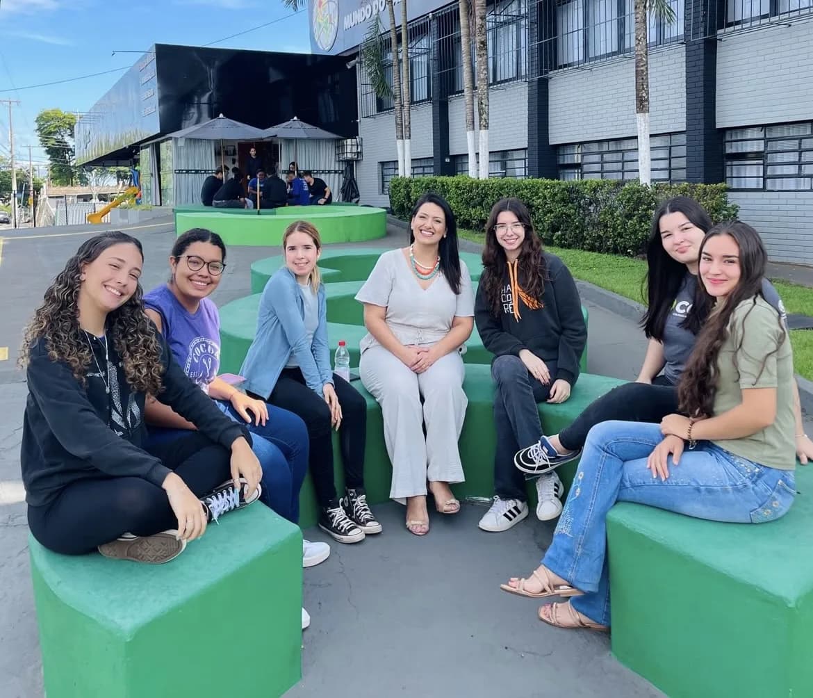 Alunas reunidas em frente à fachada do Colégio Mundo do Saber